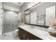 Modern bathroom featuring marble countertop, dark wood cabinets, and tiled glass shower at 16119 Carencia Ln, Odessa, FL 33556