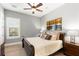 Comfortable bedroom with wood-look tile floor, ceiling fan, and triple painting above the bed at 16119 Carencia Ln, Odessa, FL 33556