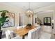 Dining room with a modern chandelier, wood table, and archway leading to the grand foyer with natural light at 16119 Carencia Ln, Odessa, FL 33556