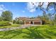 Paver driveway leads to an estate home, surrounded by lush green grass and mature trees providing shade at 16119 Carencia Ln, Odessa, FL 33556