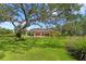 Estate-style home is surrounded by mature trees and landscaping, providing ample privacy and curb appeal at 16119 Carencia Ln, Odessa, FL 33556