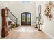 Inviting foyer featuring a staircase, stylish decor, and elegant double doors with decorative ironwork at 16119 Carencia Ln, Odessa, FL 33556