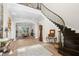 Spacious foyer with a grand staircase, wood floors, and an arched doorway leading to the dining area at 16119 Carencia Ln, Odessa, FL 33556