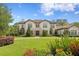 Elegant two-story home featuring manicured landscaping, a brick driveway, and stately architectural details at 16119 Carencia Ln, Odessa, FL 33556