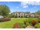 Elegant two-story home featuring manicured landscaping, a brick driveway, and stately architectural details at 16119 Carencia Ln, Odessa, FL 33556