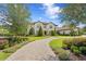 Elegant two-story home featuring manicured landscaping, a brick driveway, and stately architectural details at 16119 Carencia Ln, Odessa, FL 33556