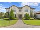 Elegant two-story home featuring manicured landscaping, a brick driveway, and stately architectural details at 16119 Carencia Ln, Odessa, FL 33556