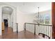 Hallway with chandelier, hardwood floor, wrought iron banister, and transom windows at 16119 Carencia Ln, Odessa, FL 33556