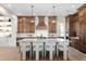 Gourmet kitchen boasts a large island with seating, pendant lighting, and custom cabinets at 16119 Carencia Ln, Odessa, FL 33556