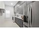 Laundry room with gray cabinets, marble countertops, stainless steel refrigerator, and a washing machine at 16119 Carencia Ln, Odessa, FL 33556