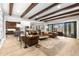 Expansive living room boasts wood beam ceilings, leather furniture, and seamless flow to kitchen at 16119 Carencia Ln, Odessa, FL 33556