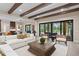 Spacious living room with wood beams, white couch, and view of the outdoor patio at 16119 Carencia Ln, Odessa, FL 33556