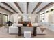 Open living room with wood beams, white couch, console and cabinet with decor at 16119 Carencia Ln, Odessa, FL 33556