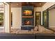 Covered outdoor area features a stone fireplace, wooden mantel, and comfortable outdoor seating at 16119 Carencia Ln, Odessa, FL 33556