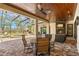 Covered outdoor living area with fireplace, seating, ceiling fans, and access to the pool area at 16119 Carencia Ln, Odessa, FL 33556