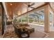 Inviting covered patio featuring a wood ceiling, outdoor kitchen, seating area, and a view of the pool at 16119 Carencia Ln, Odessa, FL 33556