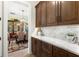 Walk-in pantry featuring custom wood cabinets, marble countertops, and additional dining room area at 16119 Carencia Ln, Odessa, FL 33556
