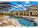 Beautiful screened-in pool with a spa and stone patio, offering a relaxing outdoor space at 16119 Carencia Ln, Odessa, FL 33556