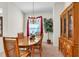 Formal dining room featuring wood table, chandelier, and bright window with red drapes at 19106 Abercorn Pl, Lutz, FL 33558
