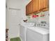 Bright laundry room with cabinetry above the washer and dryer and a white door at 19106 Abercorn Pl, Lutz, FL 33558