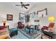 Cozy living room with comfortable seating, ceiling fan, and windows with decorative valances at 19106 Abercorn Pl, Lutz, FL 33558