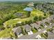 Aerial view of a home with beautiful landscaping, a two car garage and views of a golf course and pond at 1916 Inverness Greens Dr, Sun City Center, FL 33573