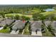 Aerial view of a home with beautiful landscaping, a two car garage and views of a golf course and pond at 1916 Inverness Greens Dr, Sun City Center, FL 33573