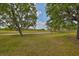 Beautiful backyard with expansive green space, mature trees, and walking paths at 1916 Inverness Greens Dr, Sun City Center, FL 33573