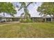 A well-maintained backyard with a screened-in porch and lush landscaping, perfect for outdoor relaxation at 1916 Inverness Greens Dr, Sun City Center, FL 33573