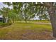 Backyard view of a lush green lawn and manicured landscaping with pathway beyond at 1916 Inverness Greens Dr, Sun City Center, FL 33573