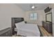 Cozy bedroom featuring stylish furniture, wood-look flooring, a window with shutters, and ample natural light at 1916 Inverness Greens Dr, Sun City Center, FL 33573