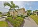 Charming home featuring a well-manicured lawn, beautiful shrubbery, and a lovely palm tree at 1916 Inverness Greens Dr, Sun City Center, FL 33573
