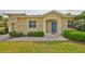 Inviting front entrance featuring a blue door, manicured bushes, and tasteful exterior lighting at 1916 Inverness Greens Dr, Sun City Center, FL 33573
