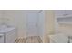 Bright laundry room with white washer, cabinets, utility sink, and wood-look flooring with easy access to the exterior at 1916 Inverness Greens Dr, Sun City Center, FL 33573