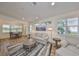Open-concept living room featuring hardwood floors, large windows, and a comfortable seating area at 1916 Inverness Greens Dr, Sun City Center, FL 33573