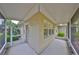 A sunny screened-in porch with a tropical garden view at 1916 Inverness Greens Dr, Sun City Center, FL 33573