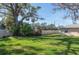Large grassy backyard surrounded by privacy fence with mature shade tree and blue skies at 2182 Corinne S Ct # C, St Petersburg, FL 33712