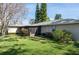 Expansive backyard featuring lush green grass, mature trees, a screened-in patio area, and neutral home exterior at 2182 Corinne S Ct # C, St Petersburg, FL 33712