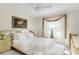 Cozy bedroom featuring a comfortable bed, a window with decorative curtains, and neutral tones at 2182 Corinne S Ct # C, St Petersburg, FL 33712