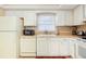 Bright eat-in kitchen with white cabinets, laminate counters, and modern appliances at 2182 Corinne S Ct # C, St Petersburg, FL 33712