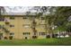 Apartment building featuring balconies, lawn, and parking area at 2221 Norwegian Dr # 43, Clearwater, FL 33763
