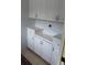 Bright laundry room offers ample storage with white cabinets and counter space at 2221 Norwegian Dr # 43, Clearwater, FL 33763