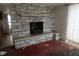 An old fireplace with a stone facade in a living room with stained red carpet at 2335 Murilla S Way, St Petersburg, FL 33712