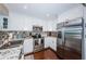 Well-lit kitchen featuring stainless steel appliances, granite countertops, a mosaic backsplash, and hardwood floors at 2515 Bay Blvd # A, Indian Rocks Beach, FL 33785