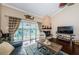 Bright living room with fireplace, hardwood floors, and sliding glass doors to balcony at 2515 Bay Blvd # A, Indian Rocks Beach, FL 33785