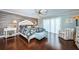 Serene main bedroom featuring wood accent wall, a ceiling fan, hardwood floors, and sliding doors for natural light at 2515 Bay Blvd # A, Indian Rocks Beach, FL 33785