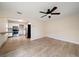 Open-concept living room with a ceiling fan, wood floors, and a view into the adjacent kitchen at 2585 9Th N Ave, St Petersburg, FL 33713