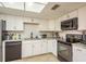 A well-lit kitchen featuring modern appliances, white cabinets, and stylish tile backsplash at 2636 Enterprise E Rd # C24, Clearwater, FL 33759