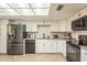 Updated kitchen with stainless steel appliances, white cabinets, and a tile backsplash at 2636 Enterprise E Rd # C24, Clearwater, FL 33759