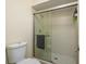 Bathroom shower features sliding glass doors, white tiles, and updated fixtures at 2636 Enterprise E Rd # C24, Clearwater, FL 33759